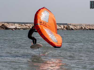 ...mentre il surfista, a cavallo della tavola, plana sospeso sull�Adriatico, librandosi in aria libero come un gabbiano